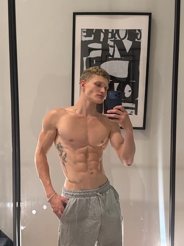 Mirror selfie showing a rose tattoo, London home interior.