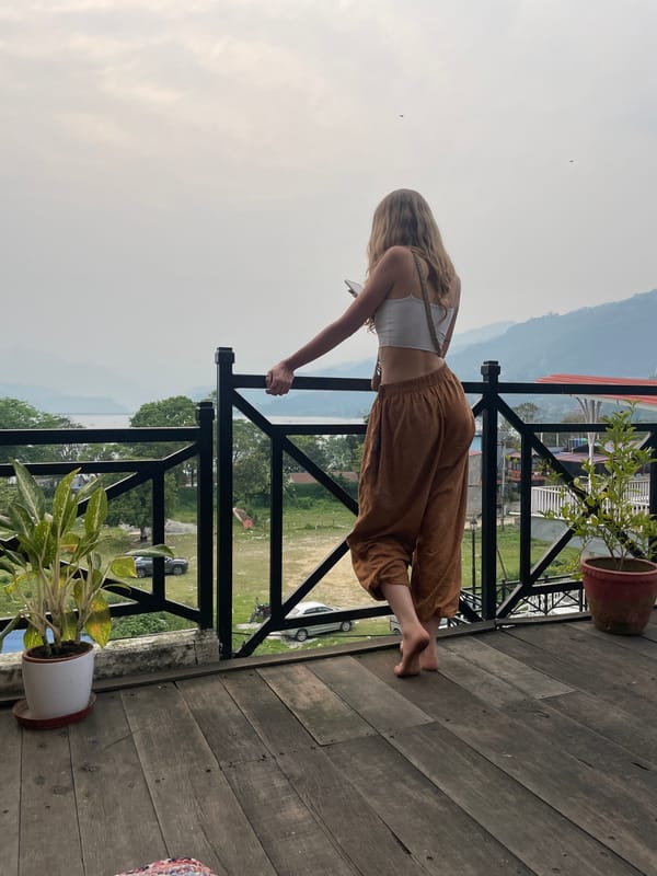 Woman observed on wooden balcony in Pokhara, Nepal