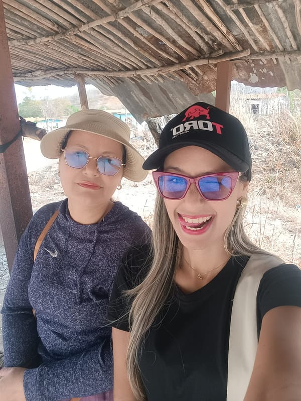 Two women pose for photo under shelter in La Pica