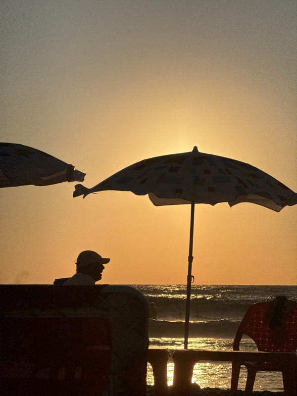 Tel Aviv beach chairs silhouetted against a warm sunset sky