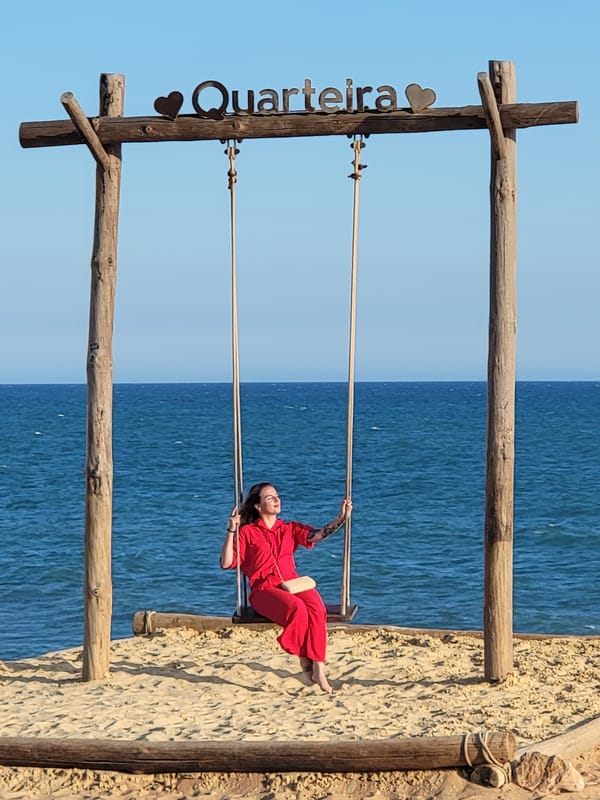 Beach swing set in Quarteira draws a crowd on a July evening.