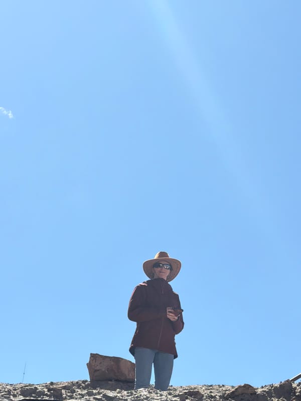 Woman in straw hat photographed near stone wall, Labrang
