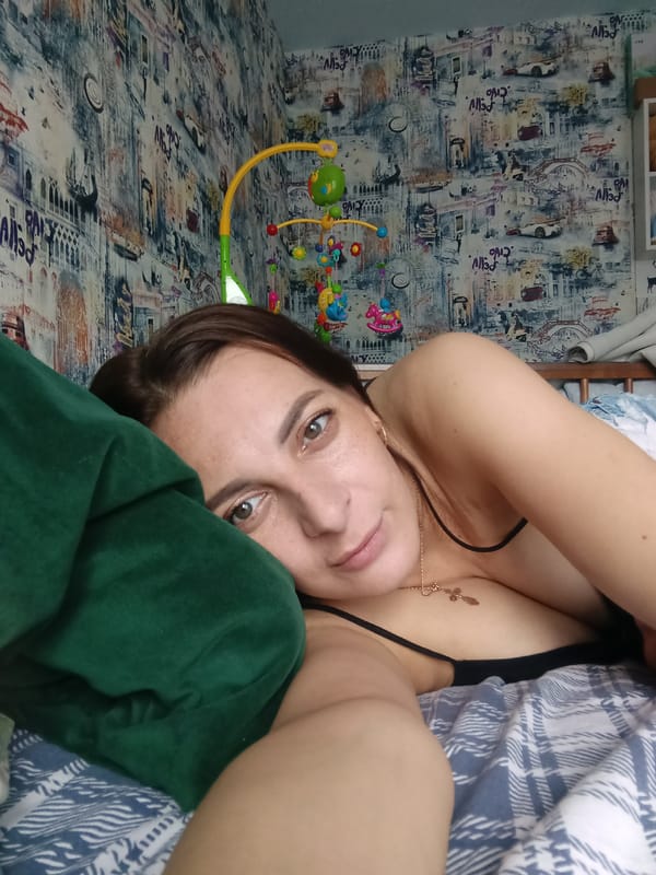 Woman rests in bed during morning hours in Andreyevo