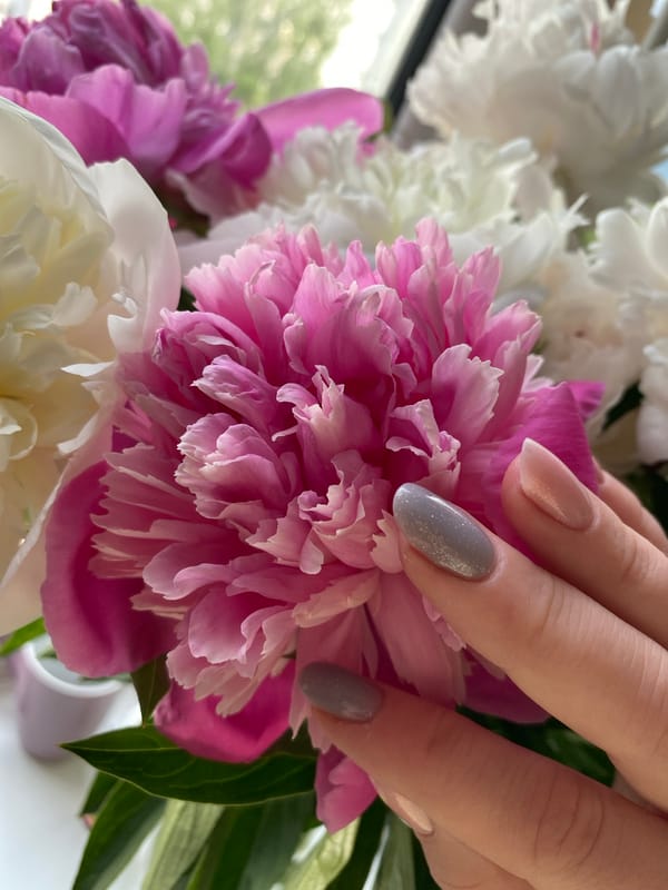 Woman poses with peony bouquet in indoor photo session