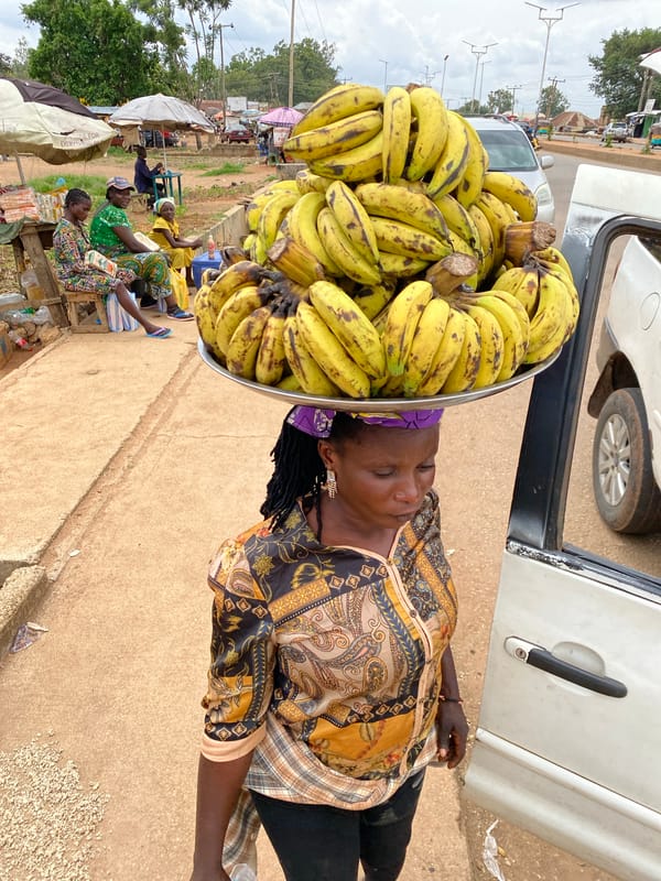 Bukuru street life: vendors, rickshaws, and road traffic midday