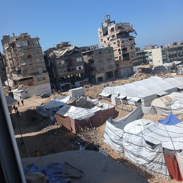 Large displacement camps documented amid damaged Gaza City buildings