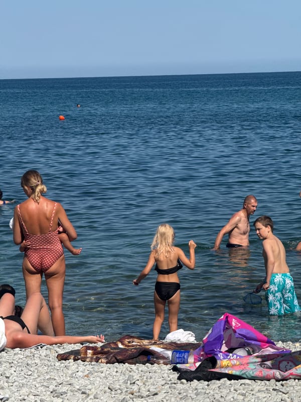 Crowded pebble beach day in Partenit, Ukraine