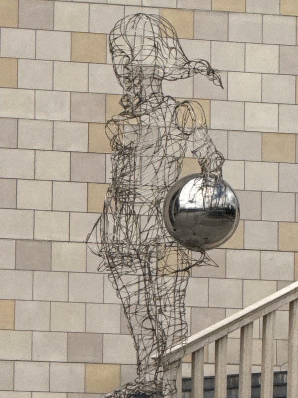 Moscow plaza: fountain play, wire sculptures, and summer crowds