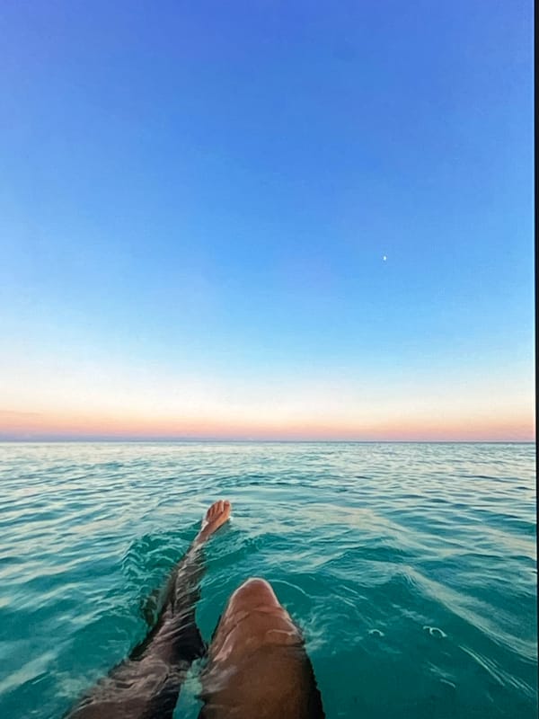 Floating in turquoise water under a gradient sky