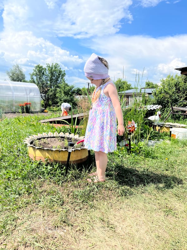 Girl plays with toys, pets in Russian village yard