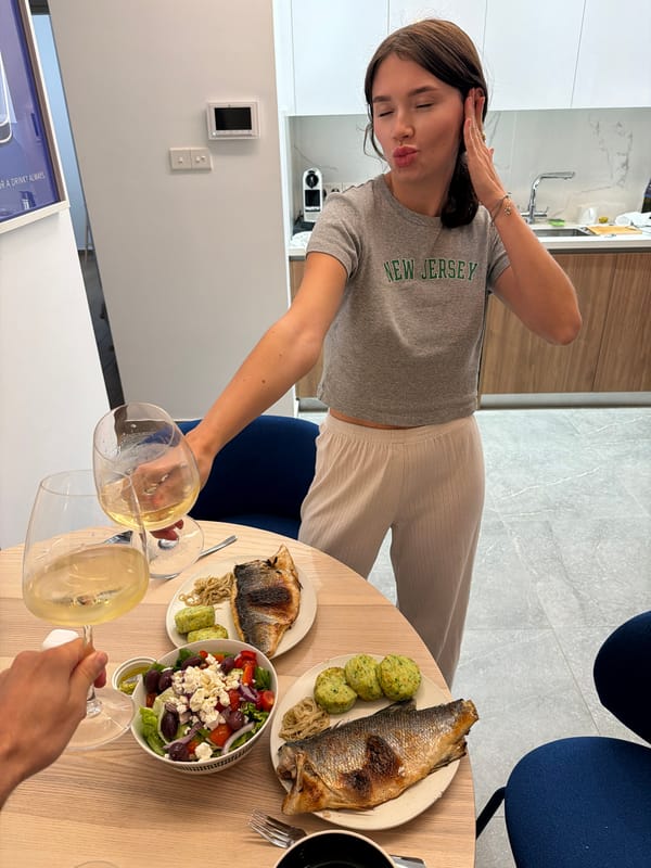Woman serves wine and fish dinner in Livadia, Cyprus