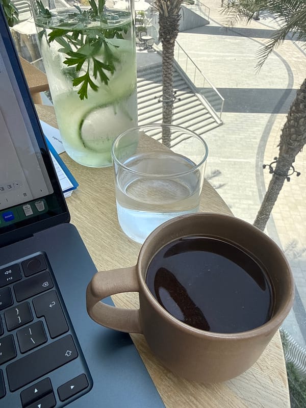 Woman enjoys morning coffee at outdoor Dubai workspace