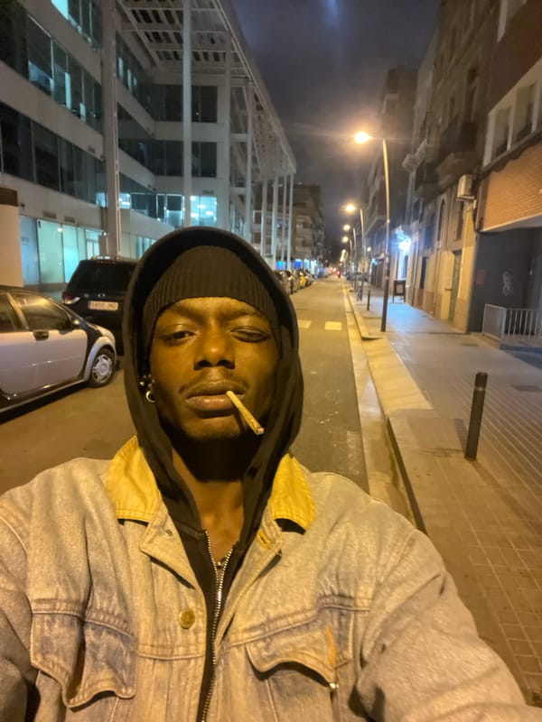 Person smoking cigarettes on Barcelona sidewalk during evening hours