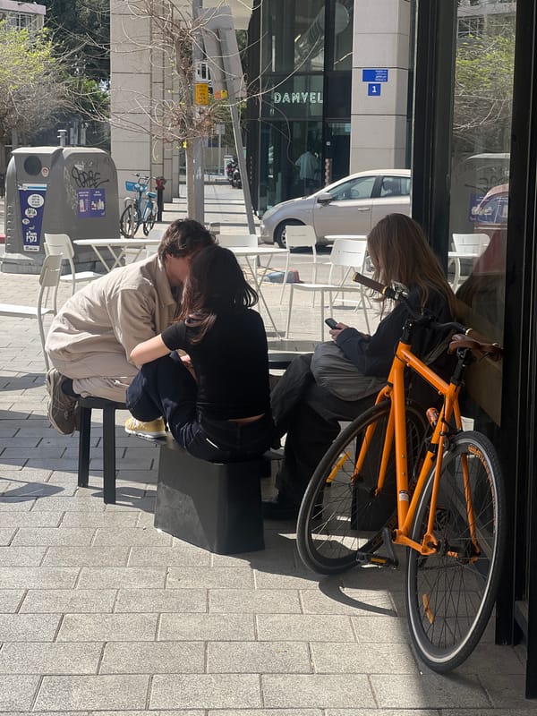 Woman takes mirror selfie with orange iPhone in Tel Aviv