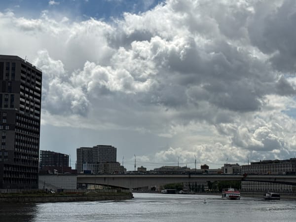 Moscow scenes: dramatic clouds over river, man in graphic tee
