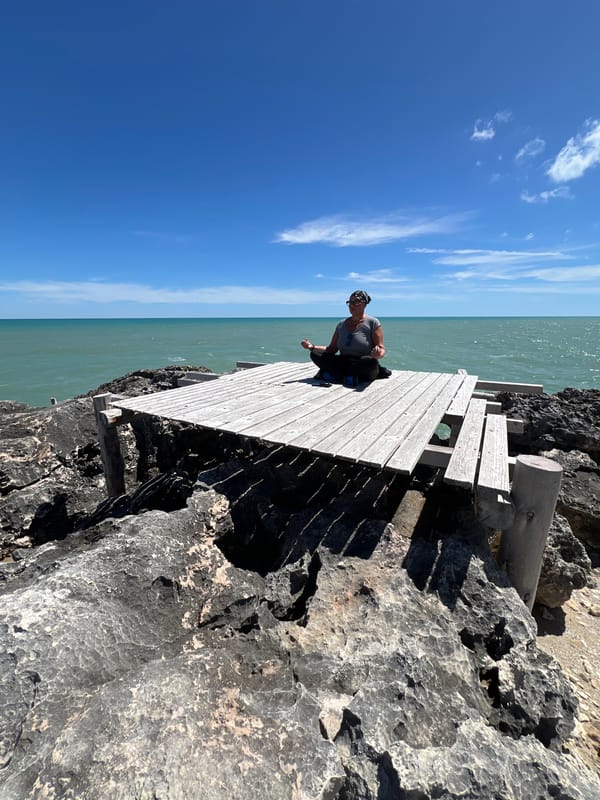Woman meditates on coastal platform in Peschici Italy