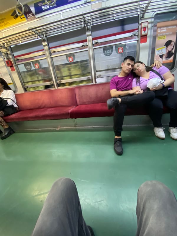 Couple lies across subway seats in Buenos Aires transit car