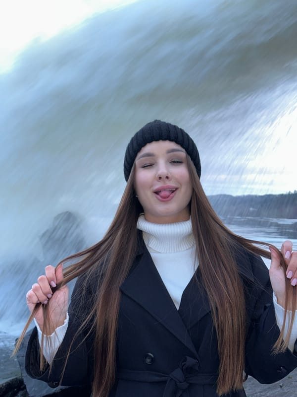 Woman poses at waterfall in Chernushka, Russia