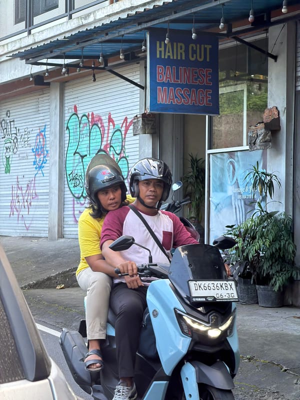 Street life and storefronts along a busy Ubud road