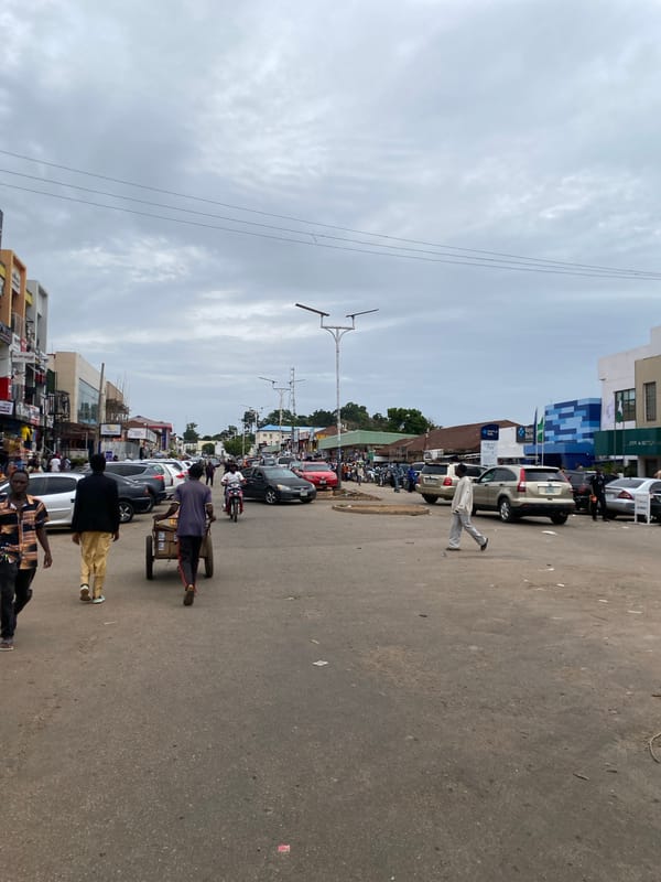 Midday street life across a busy Jos commercial district