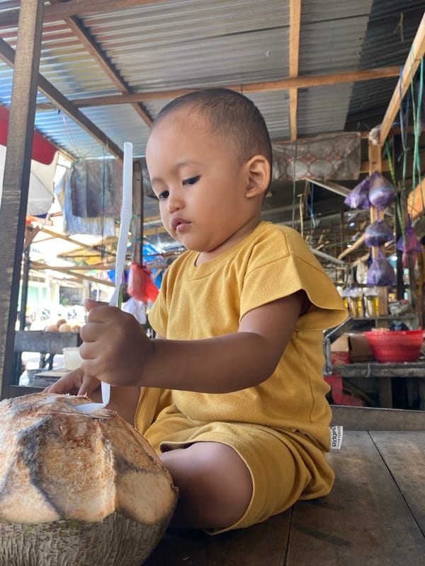 Toddler visits coconut market stall in Ta', Indonesia