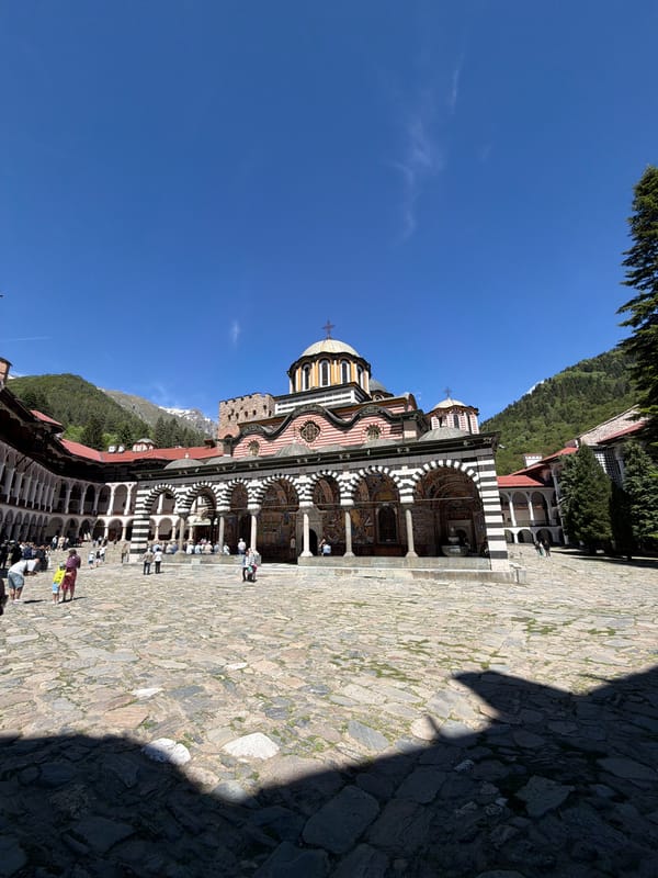 Tourist captures Rila Monastery's striped architecture during sunny visit