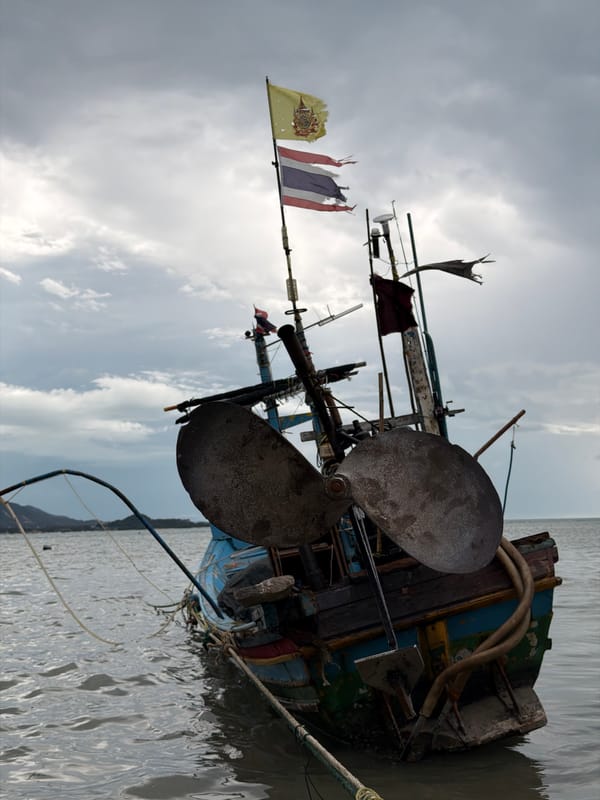 Weathered fishing boats anchored in shallow waters off Ko Samui