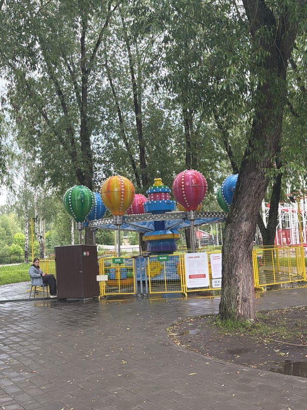 Amusement park visitors enjoy rides on cloudy afternoon