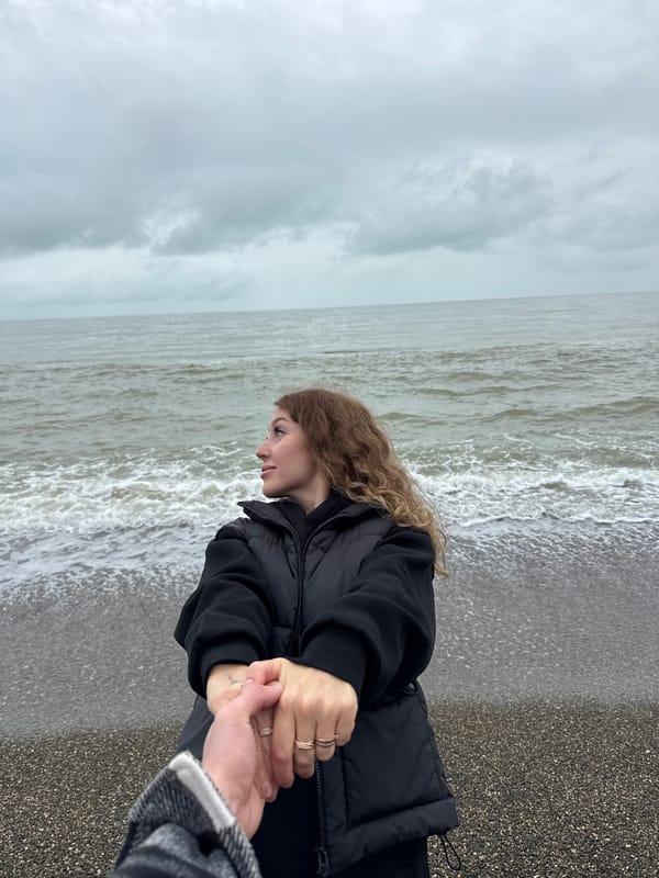 Couple holds hands on Chabkwara beach, Abkhazia
