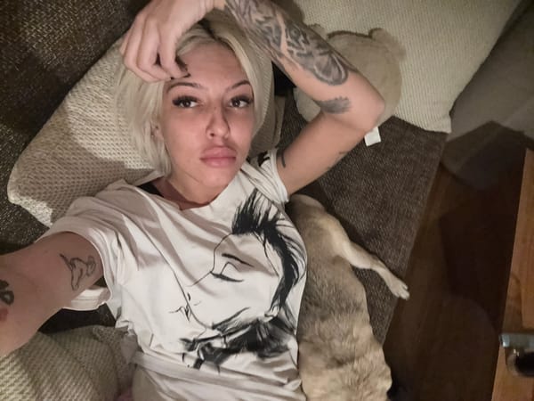 Woman takes selfies with pug in green-walled room
