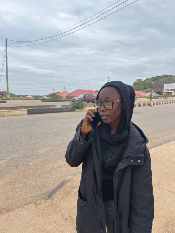 Afternoon street scene in Gura Top, Nigeria with cake and a phone call