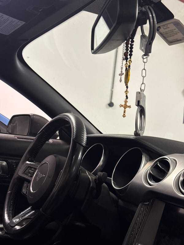Vehicle interior with handcuffs, cross necklace photographed in Dubai