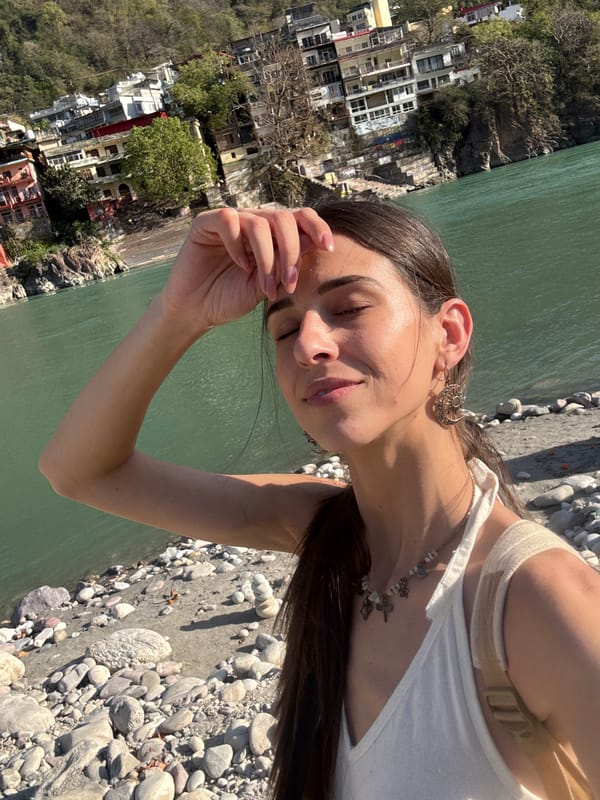 Woman enjoys peaceful moment along Ganges River in Rishikesh