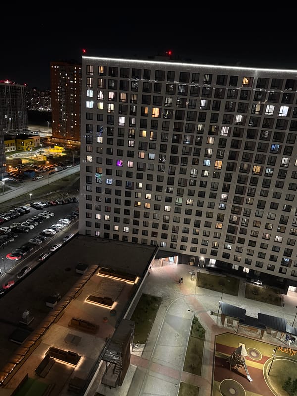 Nighttime aerial view captures illuminated residential building in Murino