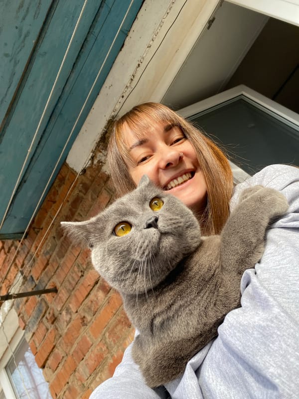 Woman holds gray cat outdoors in Votkinsk, Russia
