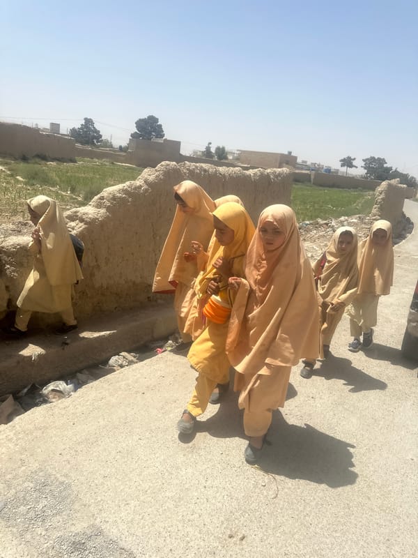 Single-file walk along a dusty path in Quetta