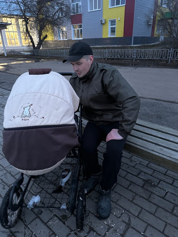 Man tends to baby stroller in Russian village