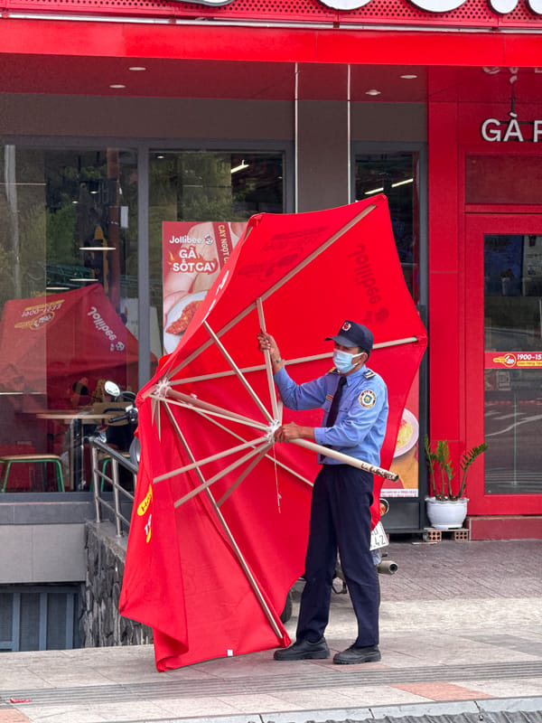 Security guard sets up Jollibee umbrella in Da Lat