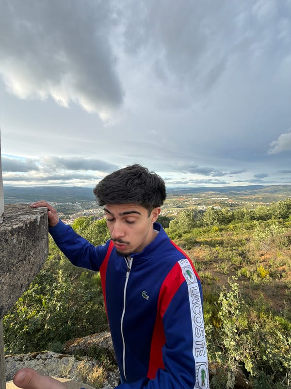 Man in Lacoste jacket overlooks Bragança from stone wall