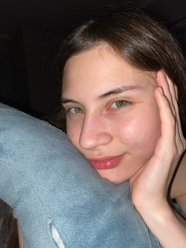 Woman takes selfies with sleeping dog on bed in Votkinsk