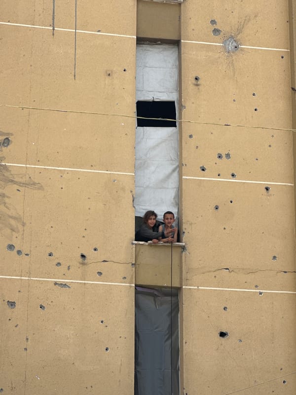Damaged buildings, displacement camps documented in unknown urban area