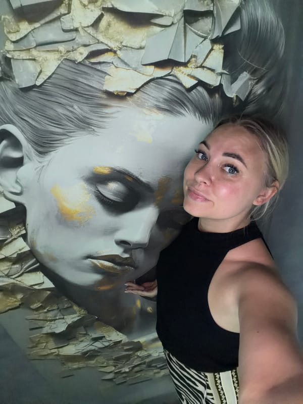 Selfies beside a gold-accented mural in Chaikovsky