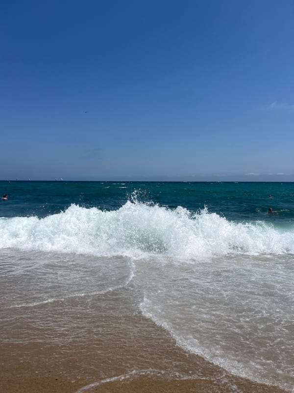 Waves breaking on a Barcelona beach, helicopter passing overhead