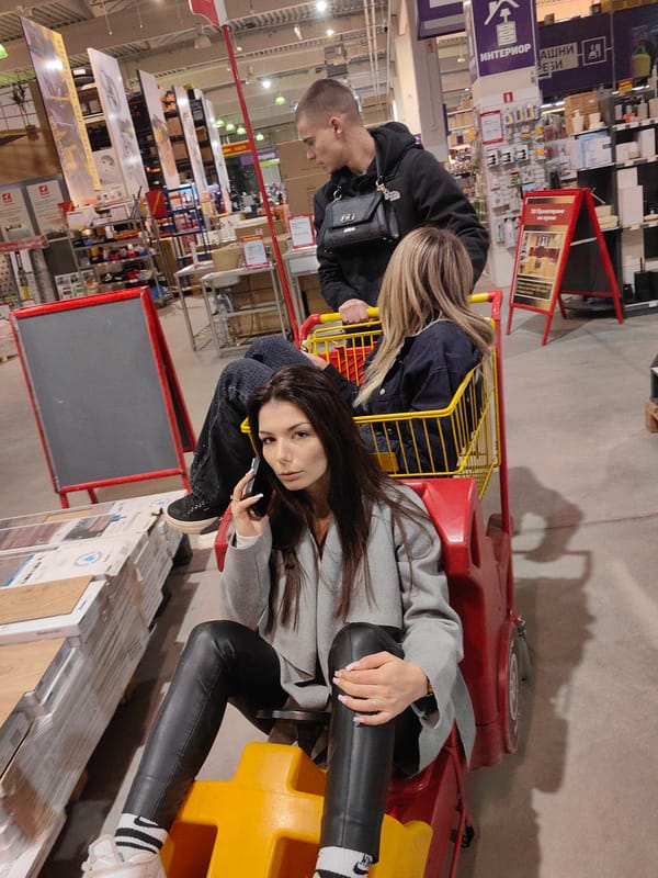 Young people ride shopping carts playfully through Sofia store