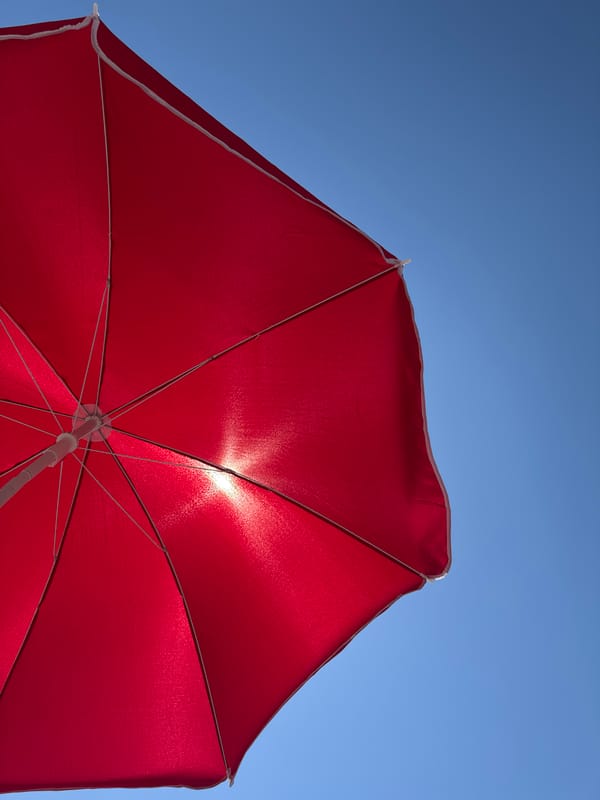 Afternoon at a Montenegro pebble beach, red umbrella and all