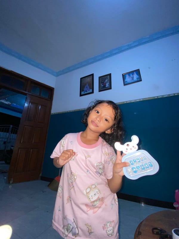 Child plays with toy phone in Indonesian home