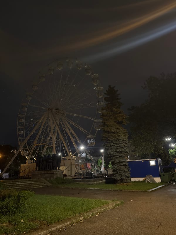 Evening fairground scene with illuminated Ferris wheel captured in Sofia
