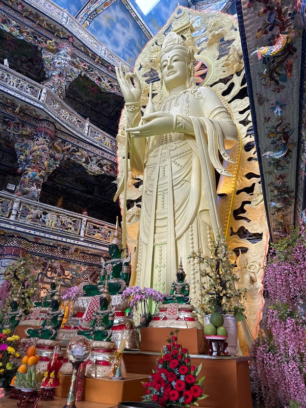 Ornate Buddhist temple complex with gold statues in Xuân Thành