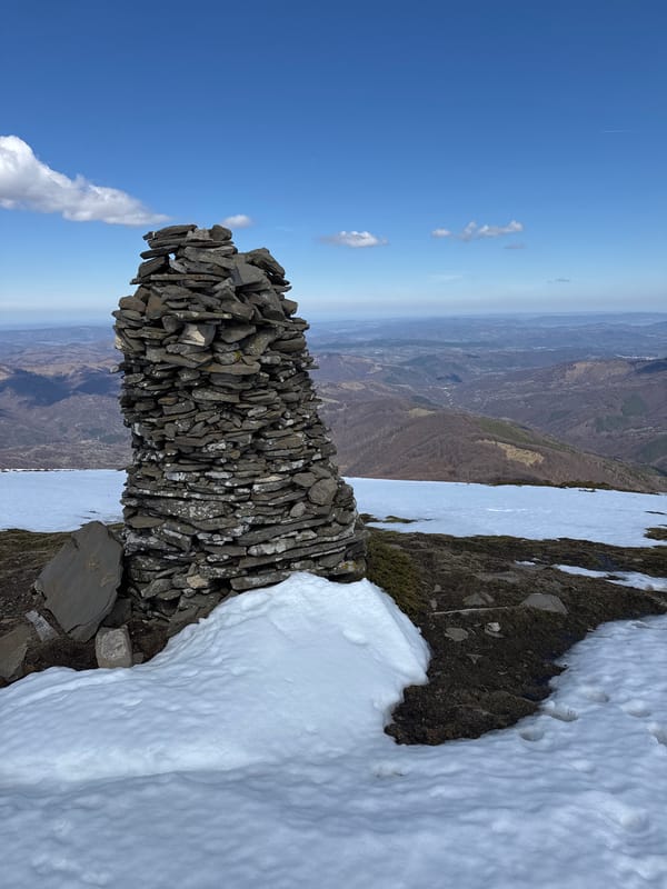 Stone cairn and snowy mountain views documented in Bulgaria