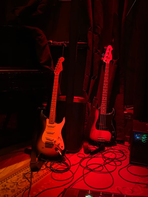 Electric guitars spotted in red-lit music venue